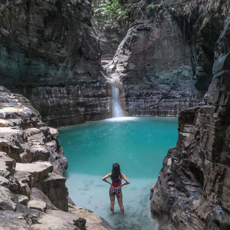 Turquoise pool below Waimarang Waterfall between rock walls