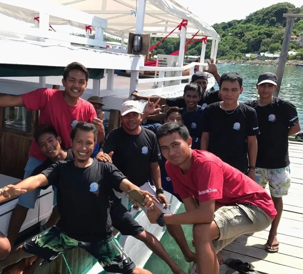 IndonesiaJuara Trip crew smiling on the deck of a boat