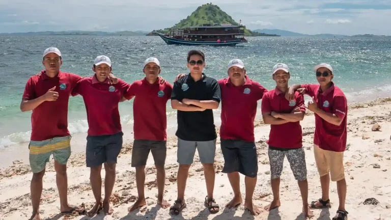 IndonesiaJuara Trip crew in red team shirts on a beach
