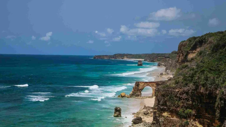 Waves breaking along the reef and rock arch of the Mbawana coastline in Southwest Sumba